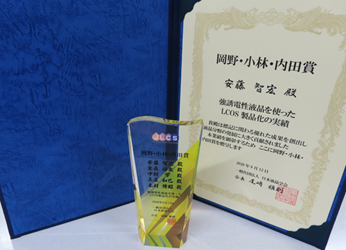 受賞した賞状と受賞者